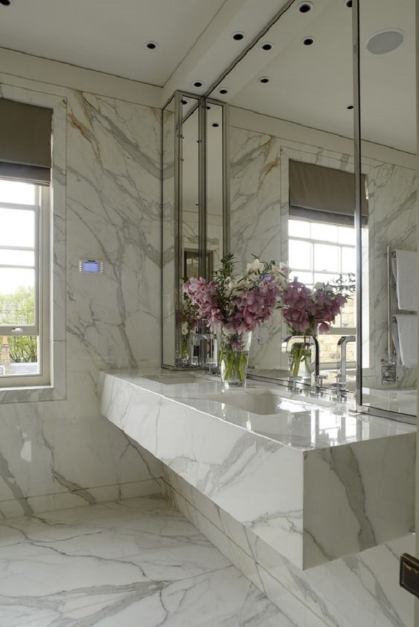 Pia de banheiro de mármore branco e revestimento nas paredes do mesmo material