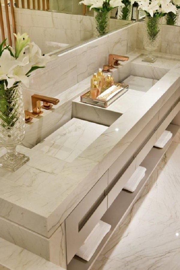 Pia de banheiro de mármore com torneiras douradas