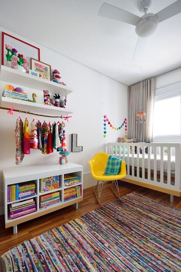 Quartinho de bebê simples decorado com tapete colorido e cadeira amarela Foto A.M Studio Arquitetura