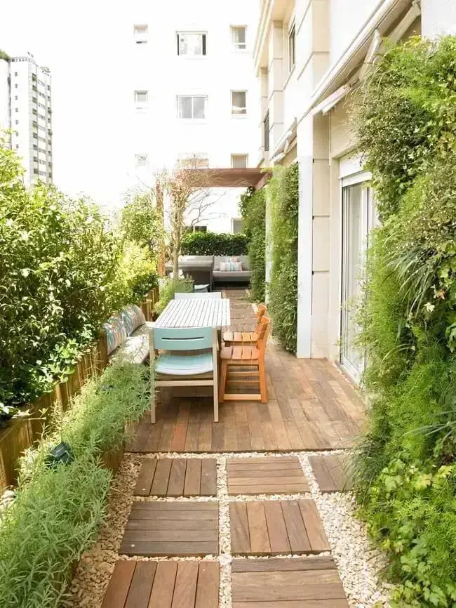 Terraço com jardim vertical externo e sofá estofado cinza. Fonte: Gigi Botelho Paisagismo