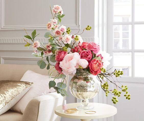Vaso prata com arranjo de mesa e flores cor de rosa