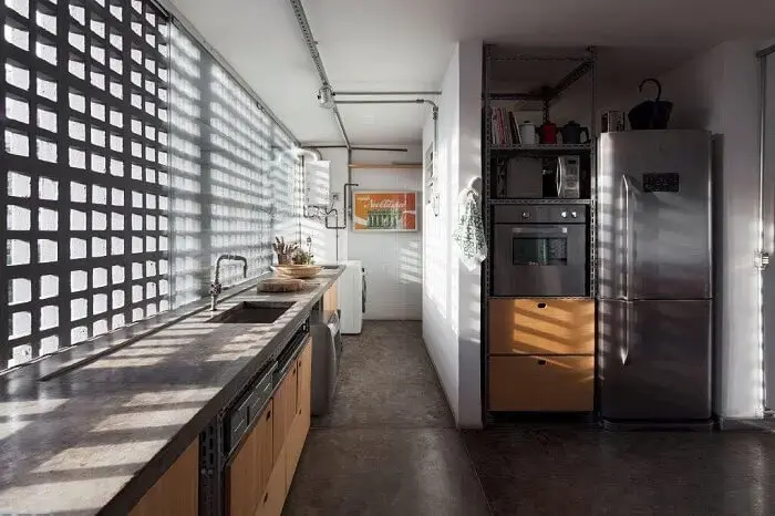 A parede de cobogó de cimento na cozinha deixa a luz natural entrar