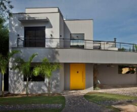 Casa com fachada cinza e porta amarela. Fonte: San Conrado de Guardini Stancati Arquitetura Designer