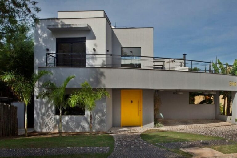 Casa com fachada cinza e porta amarela. Fonte: San Conrado de Guardini Stancati Arquitetura Designer