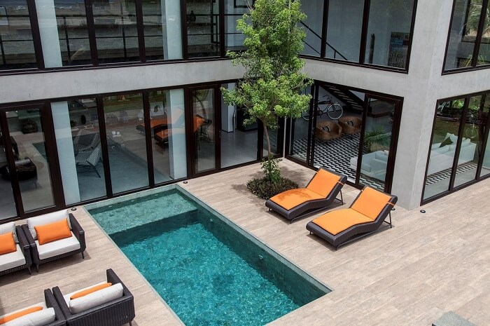 Casa com piscina retangular e fachada envidraçada