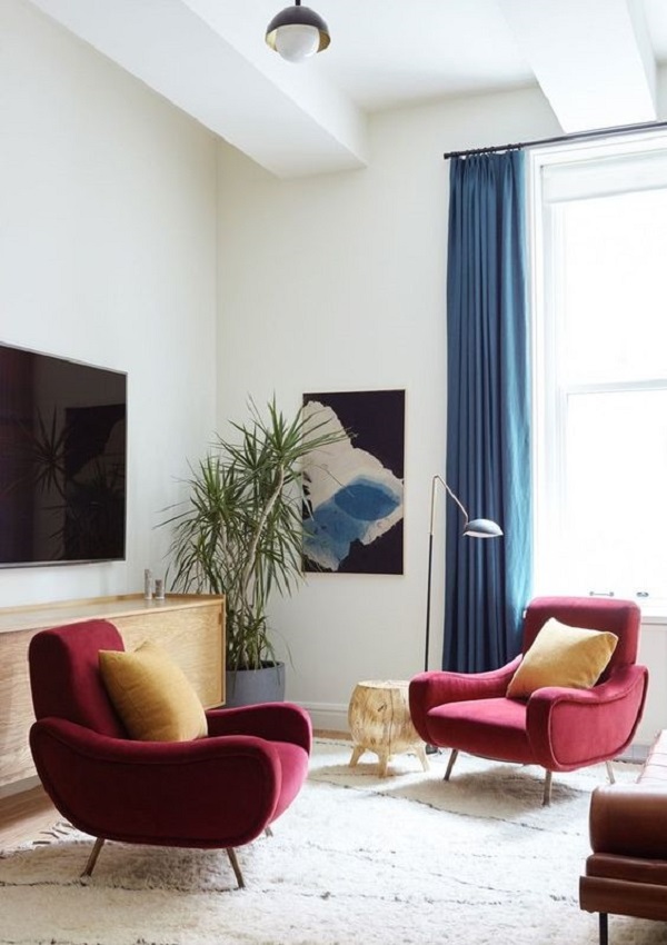 Cortina azul na sala de estar com poltrona marsala
