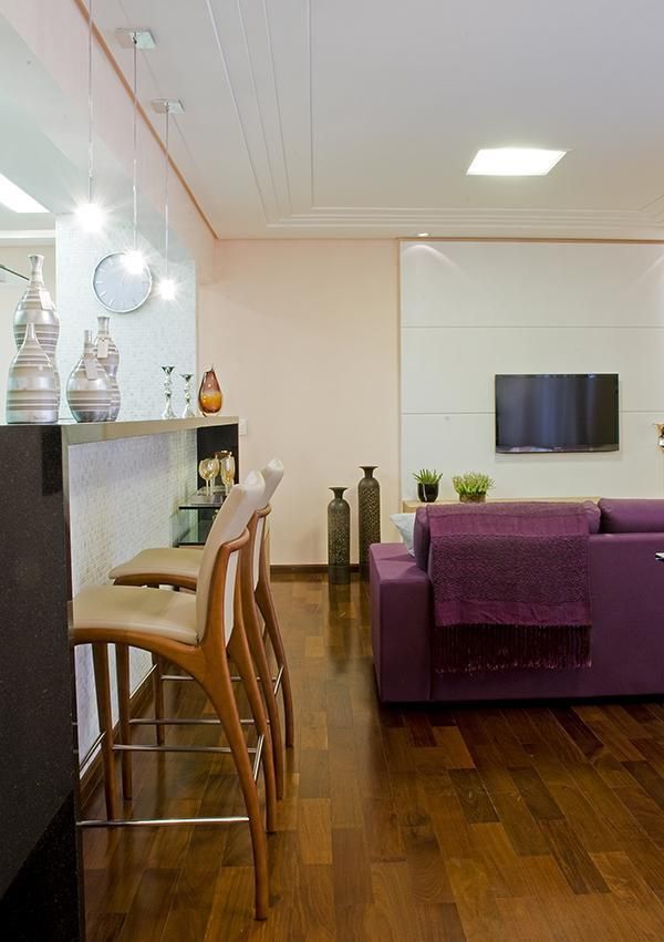 Cozinha americana simples com sala decorada com sofá roxo