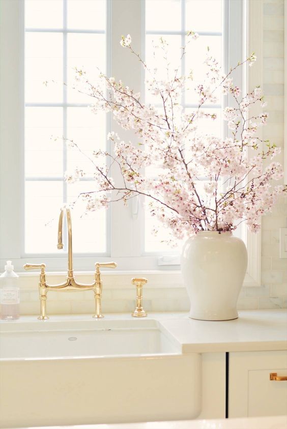 Cozinha clean com vaso de flor de cerejeira na bancada