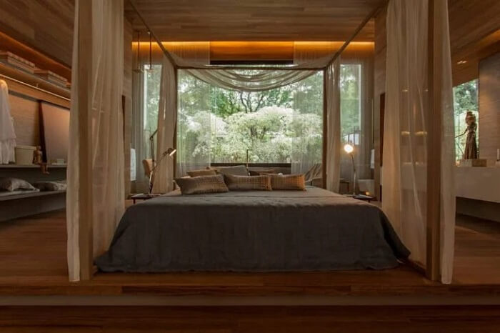O quarto com cama embaixo da janela promove momentos de relaxamento e tranquilidade