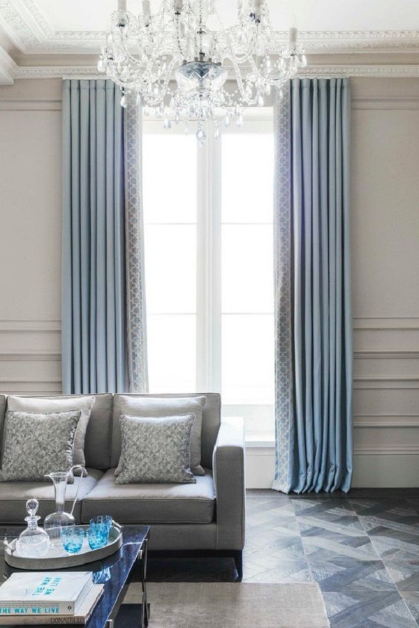 Sala cinza com cortina azul e papel de parede