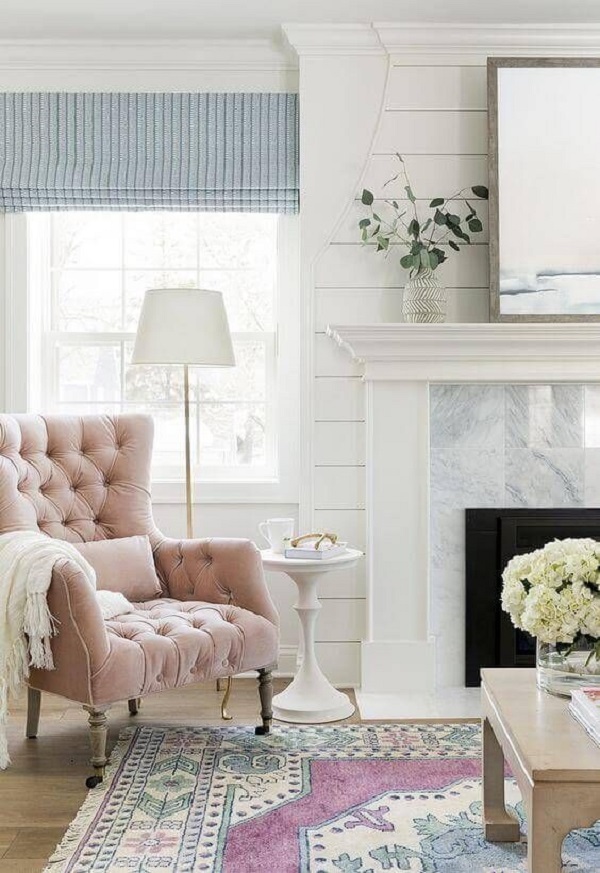 Sala com cortina azul e branca e poltrona rosa