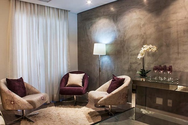 Sala de estar com marmorato na parede cinza e poltrona roxa e branca 