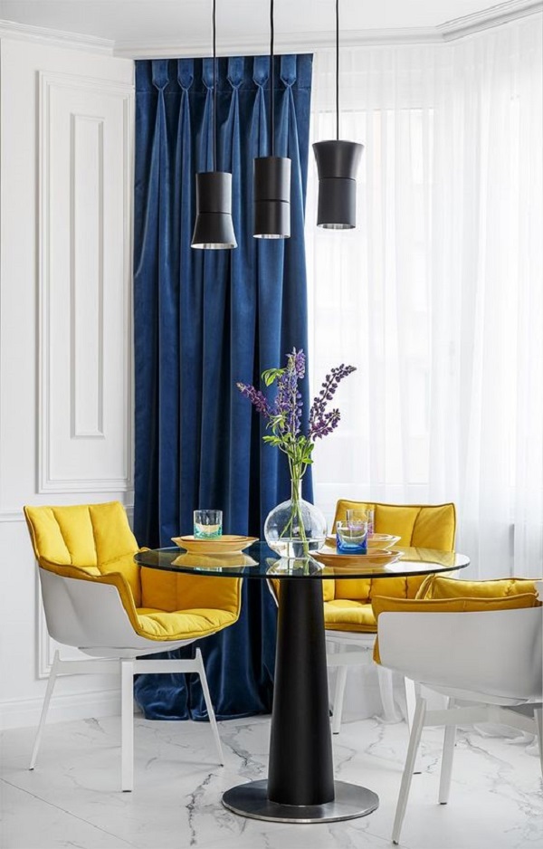 Sala de jantar com cortina azul e poltronas amarelas