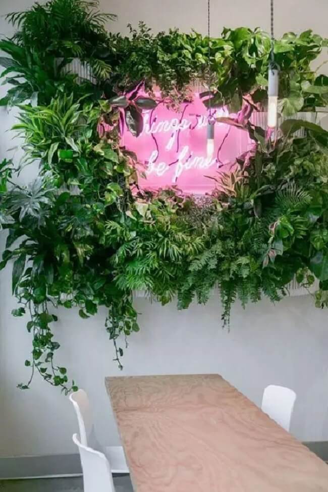 Sala de jantar com jardim vertical e letreiro neon
