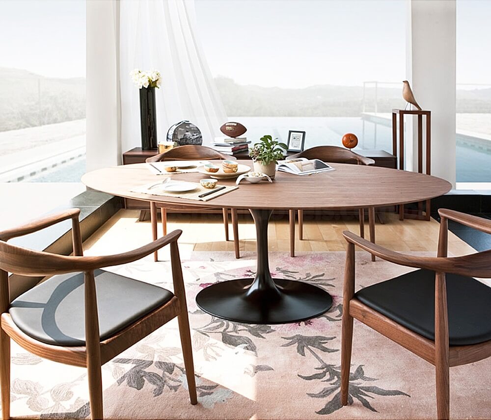 Cadeiras The Chair compostas com Mesa Saarinen em madeira. Fonte: Essência Móveis