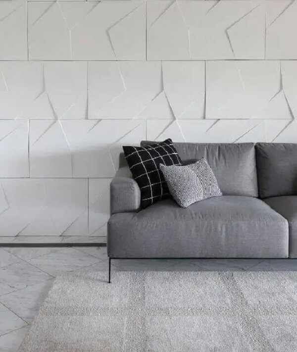 Ambiente moderno com sofá cinza e painel de gesso para sala