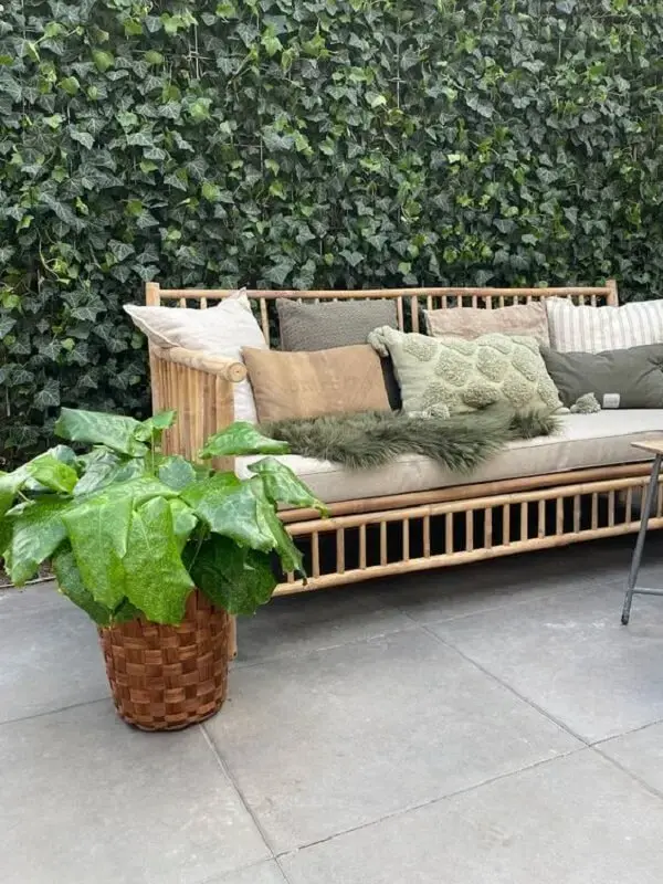 Área externa com jardim vertical e sofá de bambu