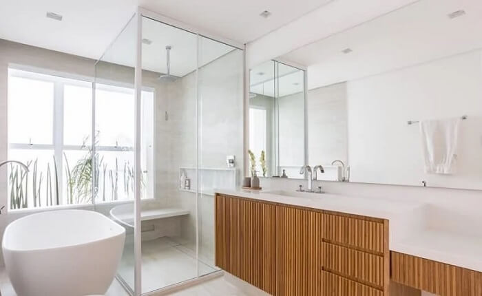Banheiro clean com armário de madeira e chuveiro de teto