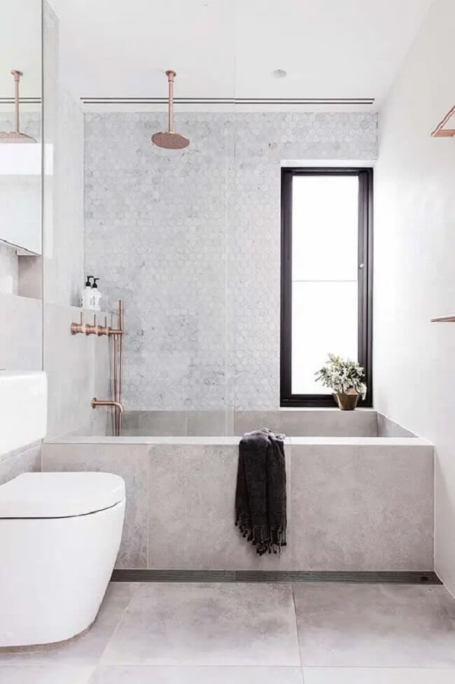 Banheiro com banheiro e chuveiro de teto rose gold