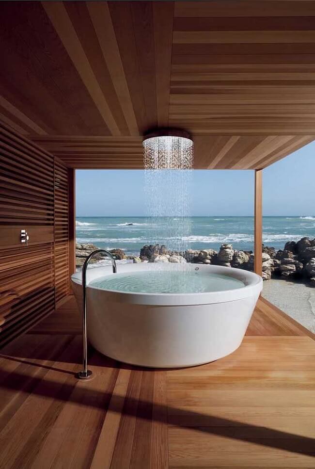 Banheiro de luxo com chuveiro de teto e vista para a paisagem do entorno