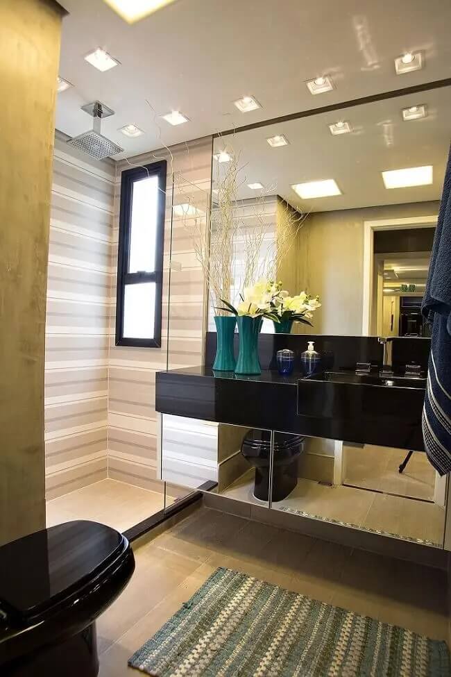 Banheiro moderno com gabinete espelhado e chuveiro de teto