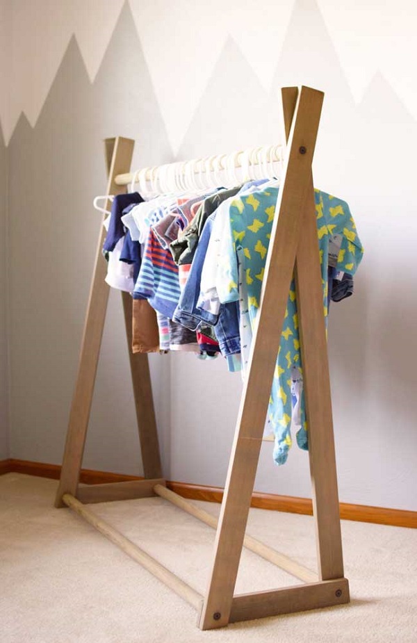 Decoração de quarto de bebê com arara de roupas de madeira