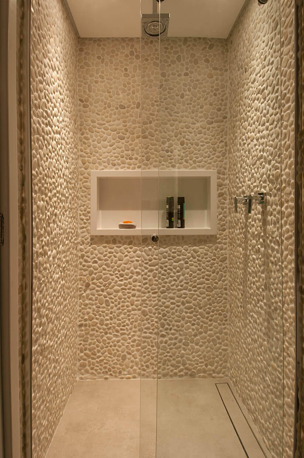 As paredes da área de banho levam seixos, pois são pedras que transmitem uma sensação de relaxamento