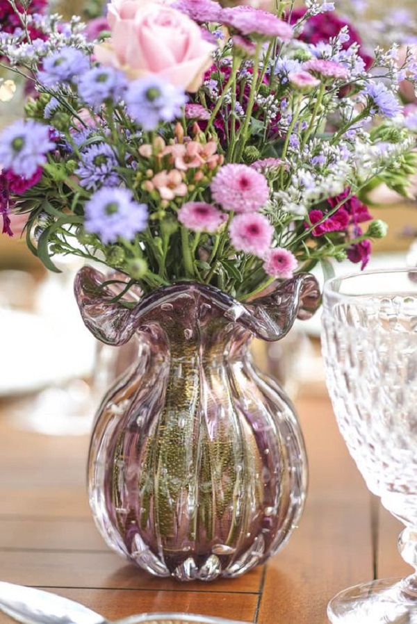 Mesa de jantar com arranjo de flores em tons de lilás