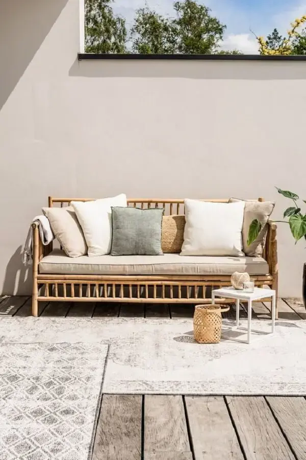 Os tapetes e almofadas trazem um toque de conforto no ambiente com sofá de bambu