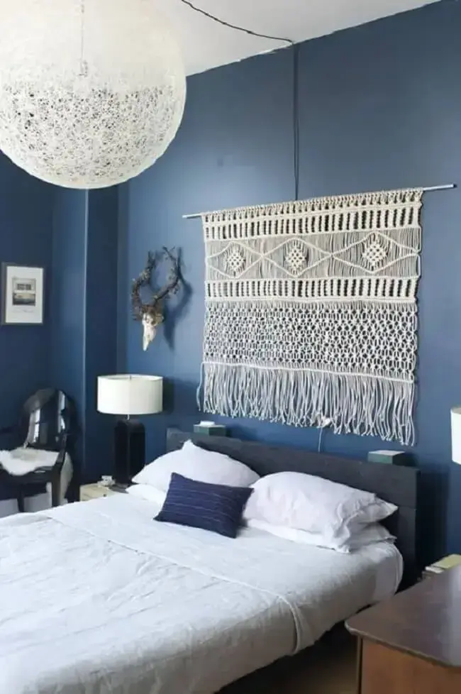 Quarto de casal azul com tapeçaria de parede macramê