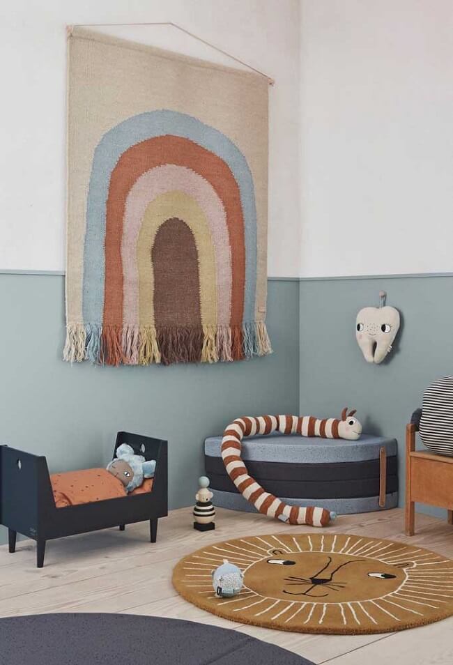 Quarto infantil decorado com brinquedos e tapeçaria de parede colorida