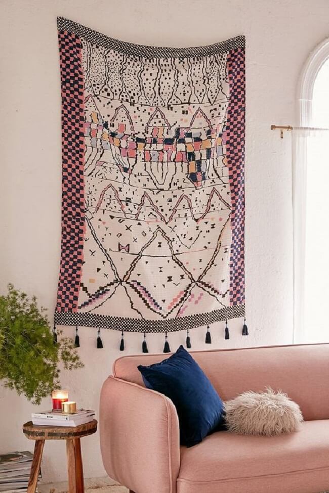 Sala de estar com sofá rosa e tapeçaria de parede