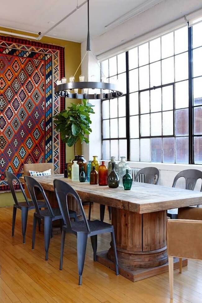 Sala de jantar com mesa de madeira e tapeçaria de parede