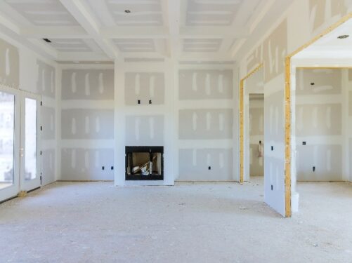 Espaço interno de uma casa em construção, com paredes de drywall