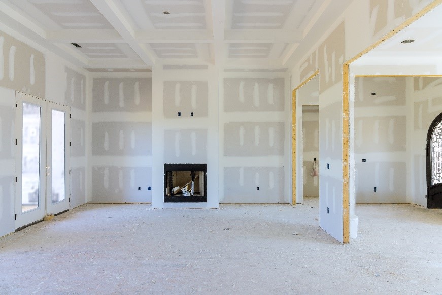 Espaço interno de uma casa em construção, com paredes de drywall