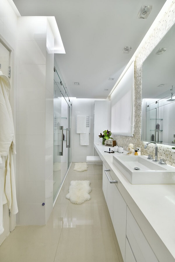 Banheiro bege com armario branco e tapetes de pelucia