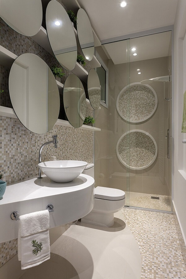 Banheiro bege com bancada branca moderna e espelho redondo