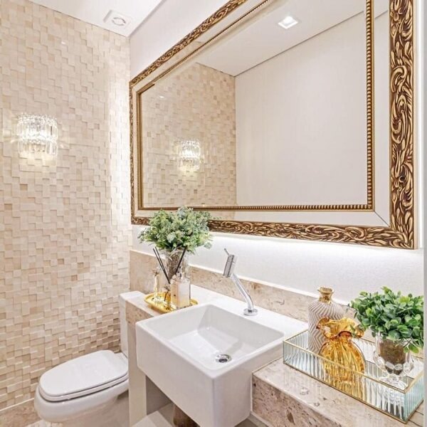 Banheiro bege com cuba de encaixe e espelho dourado