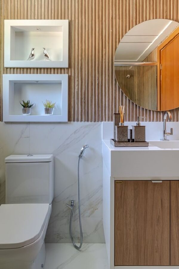 Banheiro marmorizado bege com madeira ripada na outra metade da parede