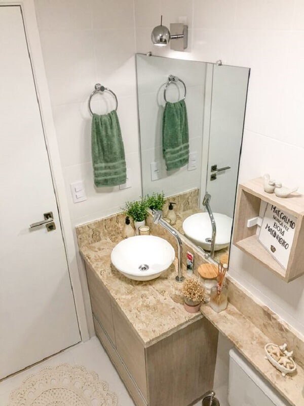 Banheiro marmorizado bege com toalha verde pendurada