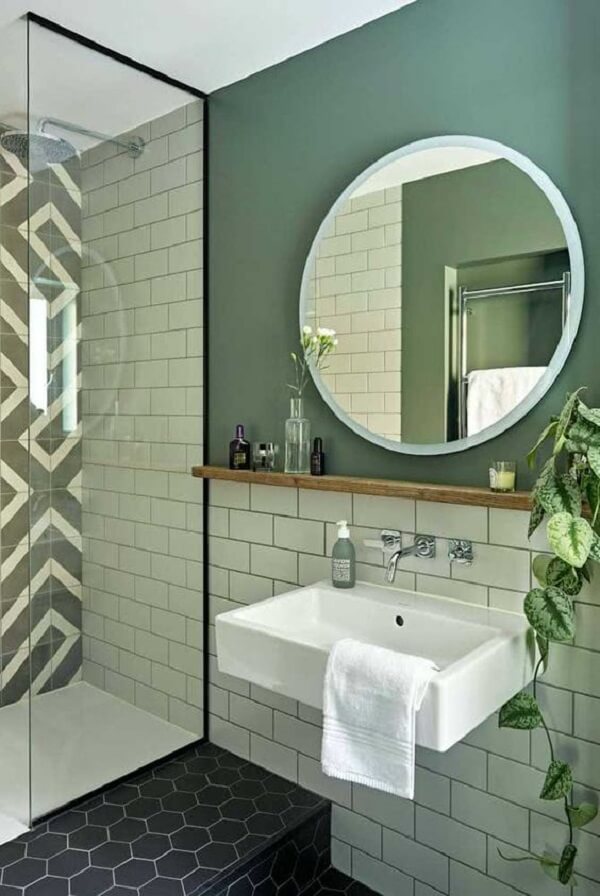 Banheiro com espelho redondo e box até o teto