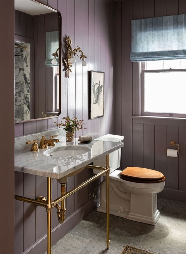 Banheiro com parede roxa e detalhes dourados