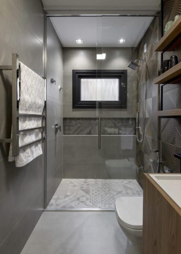 Banheiro com revestimento cinza e box até o teto