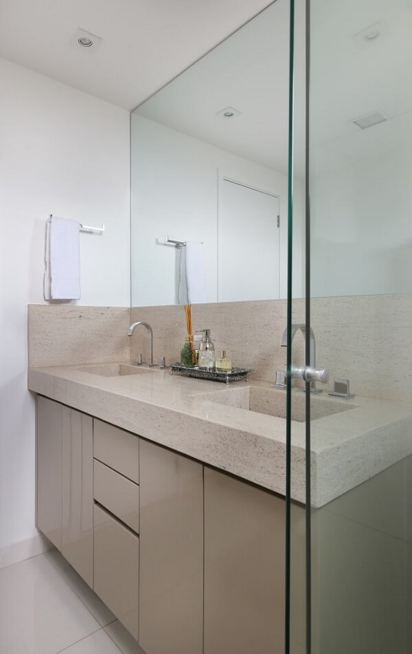 Banheiro cor areia com gabinete e bancada de mármore