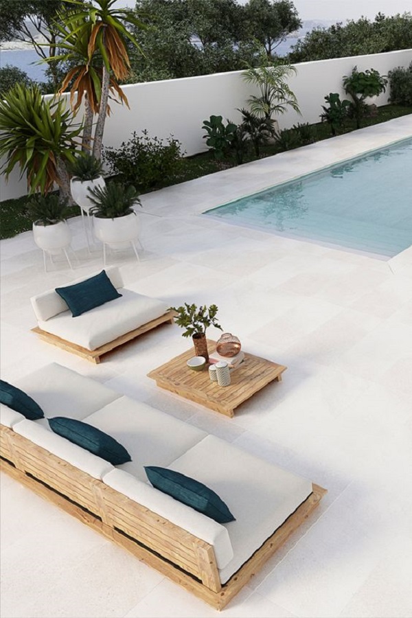 Borda de piscina de cerâmica em tons claros com sofá para área externa de madeira