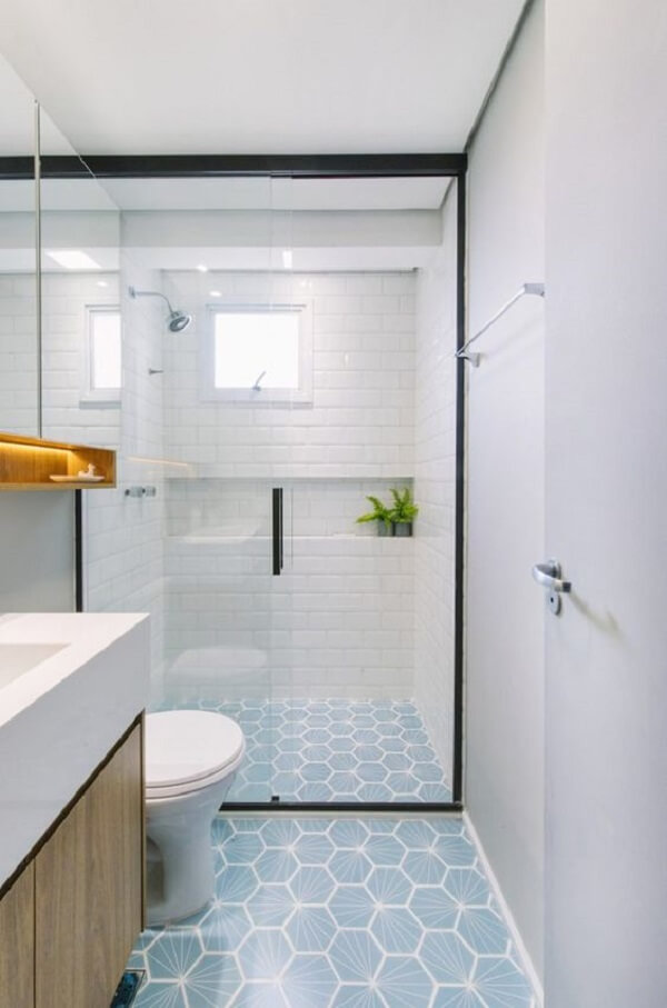 Box de banheiro até o teto e ladrilhos hidráulicos decoram o espaço