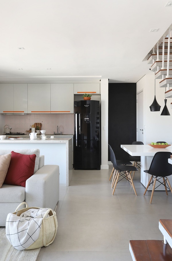 Cozinha planejada com bancada branca e geladeira preta moderna