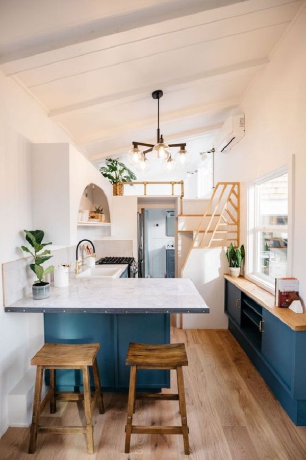 Loft pequeno com cozinha azul e quarto no mezanino