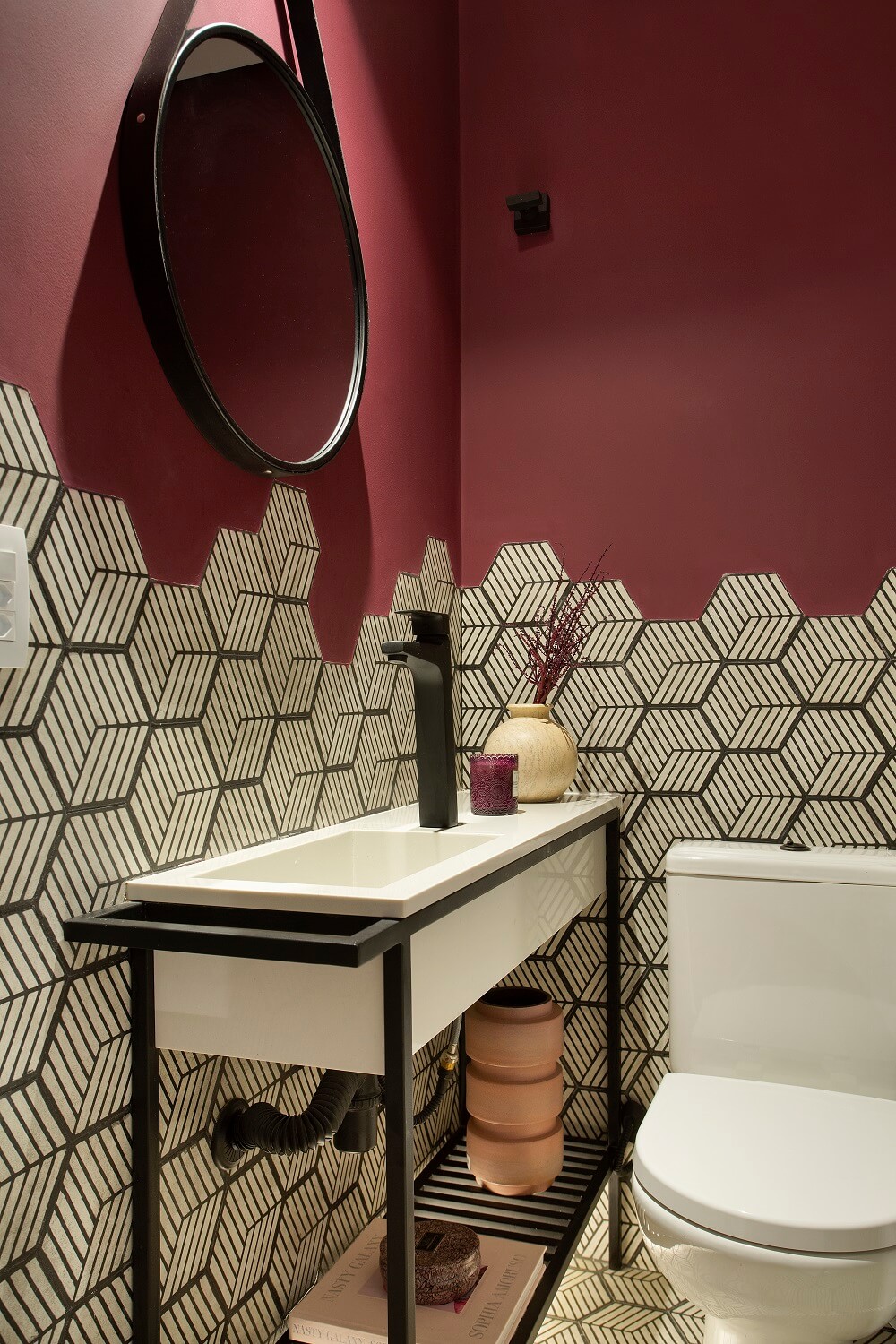 Revestimento hexagonal e espelho adnet marcam a decoração do lavabo