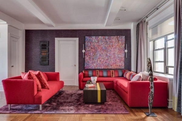 Sala com parede roxa e sofá vermelho